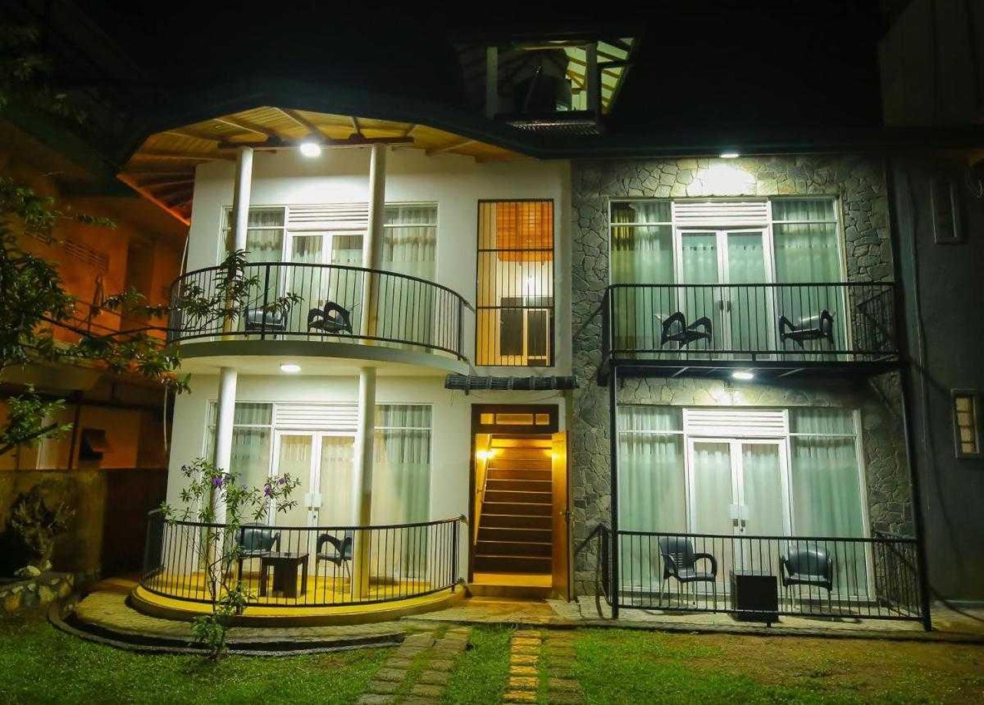 Ella Moon Rock guesthouse exterior lit up in the evening, with balconies overlooking the garden