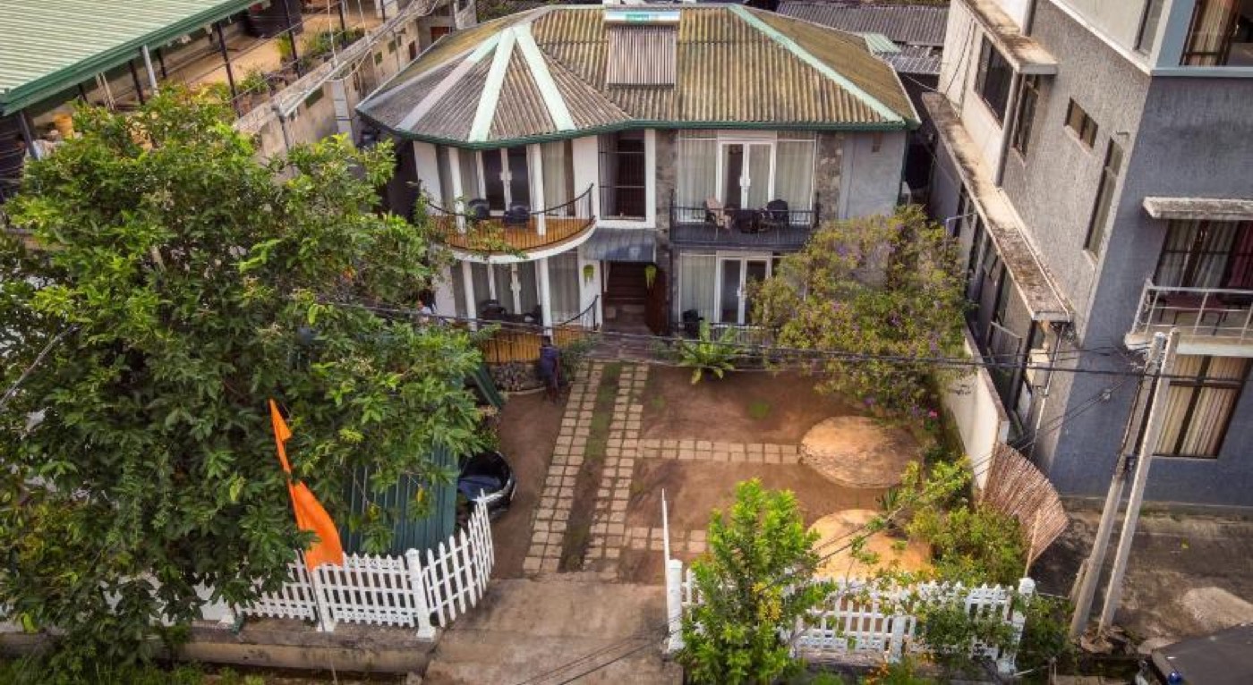 Aerial view of Ella Moon Rock guesthouse and its garden, surrounded by hillside greenery