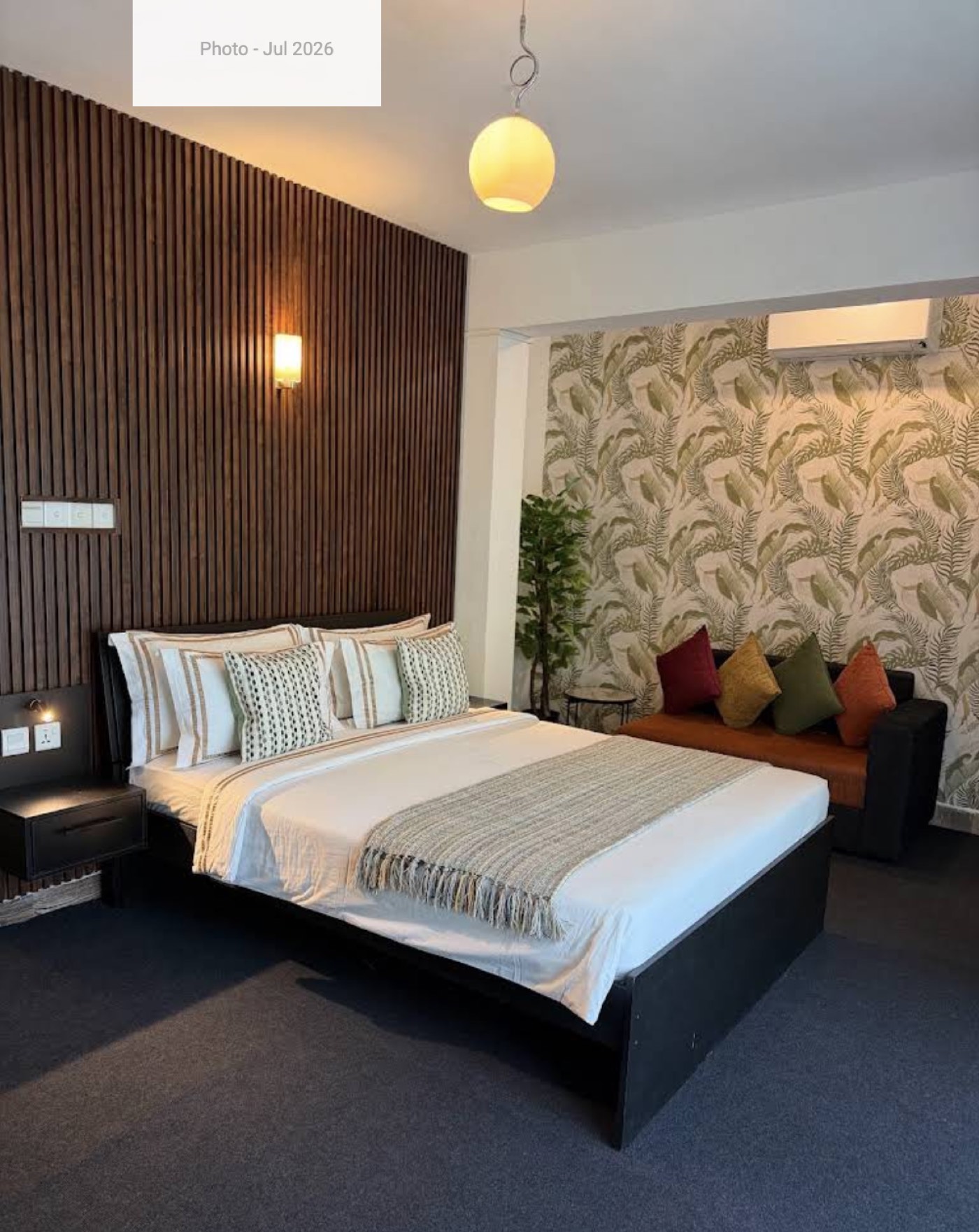 Deluxe Double room at Ella Moon Rock, with a queen bed against a dark accent wall